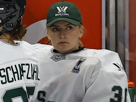 Emma Söderberg i Boston Fleets vita matchställ och grön keps i spelarbåset